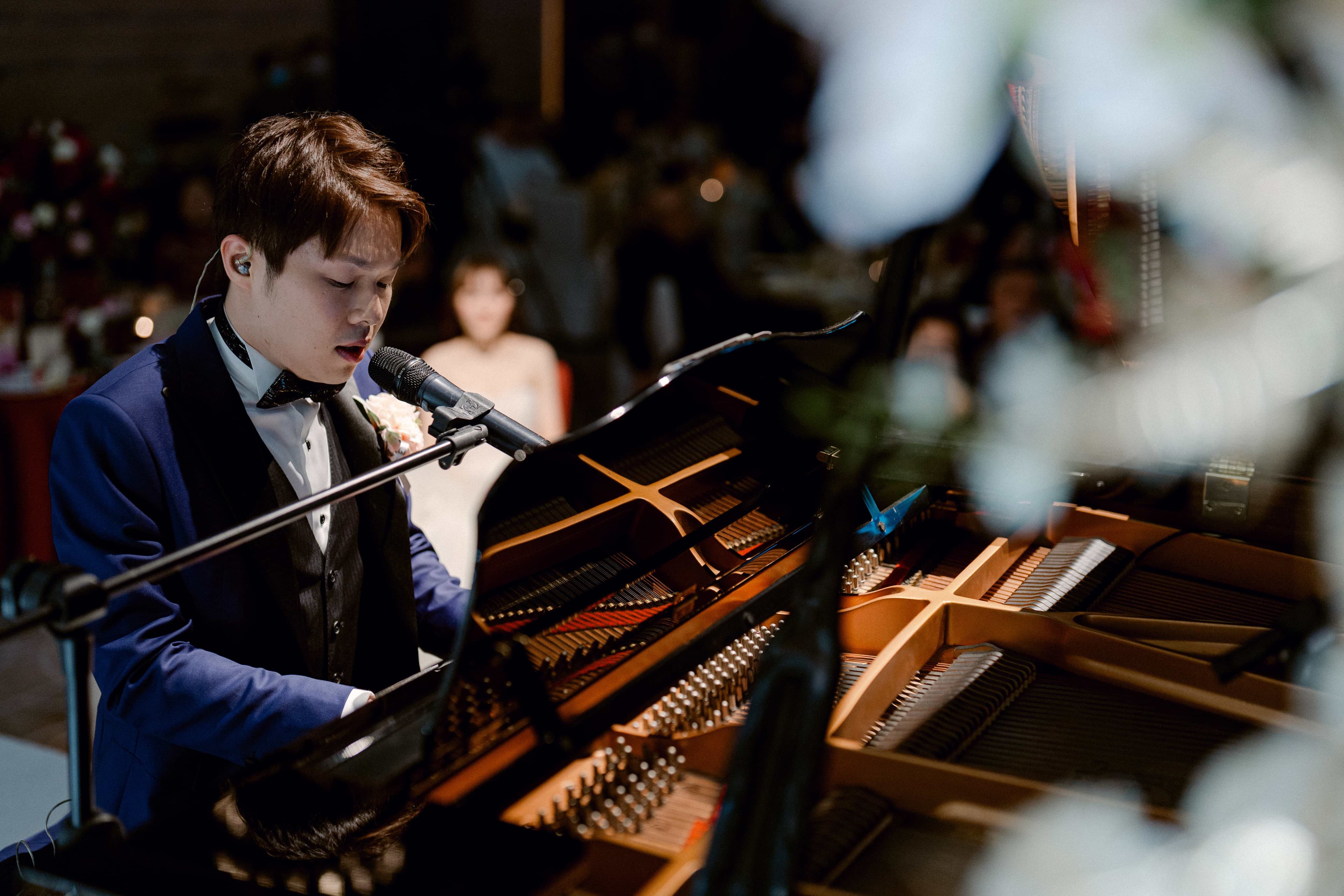 Avery Yeung performing live at a piano while singing